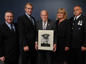 Four generations of Vancouver police officers, from left, Rick Stewart, Dave Stewart, Bob Stewart Sr., Linda Stewart and Bob Stewart Jr., pose at Vancouver in September 2011. Bob Stewart Sr. is holding a 1929 portrait of his father, Arthur Stewart, who is great-grandfather to Dave.