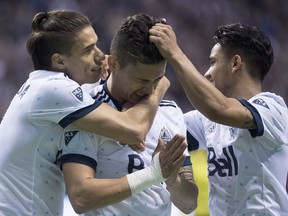 Vancouver Whitecaps' Fredy Montero, celebrates his second goal with teammates Nicolas Mezquida, left, and Christian Techera during the second half of MLS soccer action against the Seattle Sounders in Vancouver, B.C. Friday, April 14, 2017.