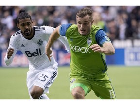 Vancouver Whitecaps' Sheanon Williams, left, fights for control of the ball with Seattle Sounders' Jordan Morris during the first half of MLS soccer action in Vancouver, B.C. Friday, April 14, 2017.