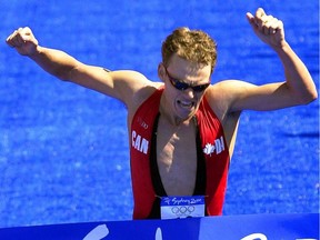 Canadian triathlon winner Simon Whitfield celebrates as he crosses the finish line in 1:48:24 to win the gold medal during the Sydney 2000 Summer Olympics Sunday September 17, 2000.