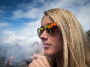 A woman smokes a joint during the annual 4/20 cannabis culture celebration at Sunset Beach in Vancouver, B.C., on Thursday, April 20, 2017.