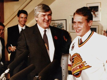 Columnist Iain MacIntyre stands in the background as Vancouver Canucks general manager Pat Quinn (left) introduces Pavel Bure (right) to the press corp at a press conference held Nov 1, 1991.