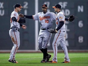 Baltimore Orioles center fielder Adam Jones (10) celebrates with right fielder Craig Gentry, right, and left fielder Joey Rickard left, after defeating the Boston Red Sox 5-2 during a baseball game at Fenway Park in Boston, Monday, May 1, 2017. (AP Photo/Charles Krupa)