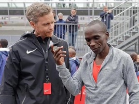 Olympic marathon champion Eliud Kipchoge, right, talks with Nike CEO and President Mark Parker, after crossing the finish line of a marathon at the Monza Formula One racetrack, Italy, Saturday, May 6, 2017. Eliud Kipchoge was 26 seconds from making history on Saturday but in the end the Olympic champion was just short of becoming the first person to run a marathon in less than two hours. Kipchoge ran the 26.2 miles (42.2 kilometers) in 2 hours and 24 seconds, beating Dennis Kimetto&#039;s world recor