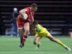 Canada&#039;s Adam Zaruba, left, fights off Australia&#039;s Stephan van der Walt during World Rugby Sevens Series&#039; Canada Sevens tournament action in Vancouver on March 12, 2016. The Canadian men&#039;s rugby sevens team arrived in Paris with a new entry on its resume - champion. THE CANADIAN PRESS/Darryl Dyck