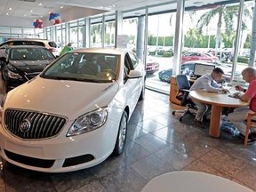 In this Wednesday, April 26, 2017, photo, client specialist Felipe A. Perdomo, left, closes a deal with customer John Tsialas at a GMC Buick dealership in Miami. U.S. household debt reached a record high in the first three months of 2017, topping the previous peak reached in 2008. Yet the nature of what Americans owe has changed since the Great Recession. Student and auto loans make up a larger proportion of household debt, while mortgages and credit card debt remain below pre-recession levels.