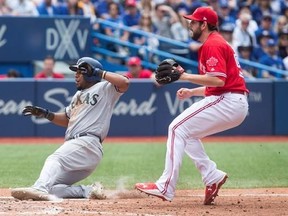 Texas Rangers shortstop Elvis Andrus (left) scores after a wild pitch from Toronto Blue Jays relief pitcher Dominic Leone (right) during seventh inning Major League baseball action in Toronto on Sunday, May 28, 2017. THE CANADIAN PRESS/Chris Young