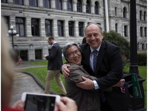 B.C. Green party leader Andrew Weaver and Green candidate Roy Sakata take a picture together following a press conference in the rose garden on the Legislature grounds in Victoria on Wednesday.