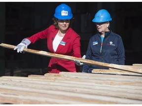 B.C. Liberal Leader Christy Clark lifts lumber as local candidate Jackie Tegart looks on as they tour NMV Lumber in Merritt on Tuesday, May 2, 2017.