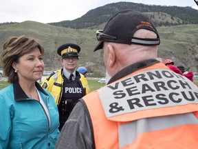 Premier Christy Clark speaks to a rescue worker as she visits Cache Creek, B.C., Saturday, May 6, 2017. The small B.C. community was hit this week with flooding from melting snow pack.