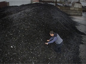 Climbing a mountain of crushed tire bits at Western Rubber Products on Annacis Island in 2004 is Western president Grant McIntosh.