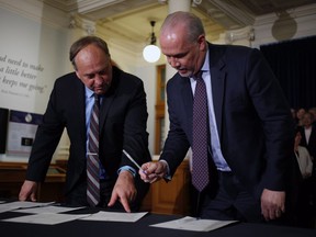 B.C. NDP leader John Horgan and B.C. Green party leader Andrew Weaver sign an agreement on creating a stable minority government during a press conference in the Hall of Honour at Legislature in Victoria, B.C., on Tuesday, May 30, 2017.