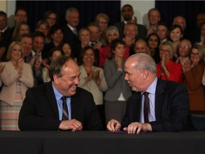 B.C. NDP leader John Horgan and B.C. Green party leader Andrew Weaver sign an agreement on creating a stable minority government during a press conference in the Hall of Honour at Legislature in Victoria, B.C., on Tuesday, May 30, 2017.