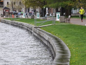 The level of Okanagan Lake continues to rise and the Central Okanagan Regional District is warning peak levels could end up half-a-meter higher than what was originally predicted. A jogger runs along a pathway through City Park in Kelowna.