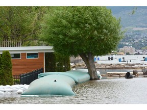 Watt Road homes are protected by a aqua dam on Wednesday. Beaches along Okanagan Lake took a pounding from a wind storm that hit Tuesday night.