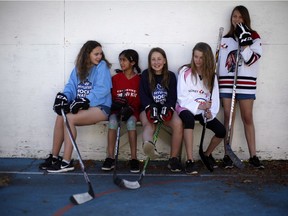 Lauren Fleetwood, (left), takes a break from street hockey with friends Selma Paul, Evie Johnson, Jamie Helmkay and Nora Weatherston. Fleetwood's father Ian is trying to create an all-girls hockey association in Victoria.