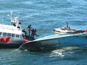 The Coast Guard dive-rescue team in action on the overturned hull of the fishing vessel Cap Rouge II. The capsizing of the vessel off Steveston in 2002 killed five people.