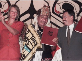 Nisga'a Nation president Joseph Gosnell is flanked by then-Premier Glen Clark and then-Minister of Indian Affairs Jane Stewart as he holds a negotiated agreement in 1998.