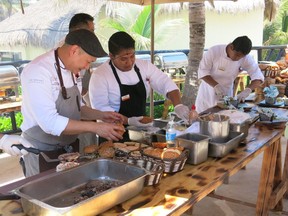 Nick Liu, left, cooking at El Dorado Canadian burger barbecue with resort chefs.