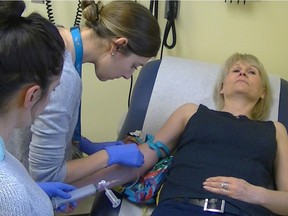 Researchers draw blood from a volunteer for the Human Vaccines Project.