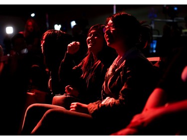 NDP supporters are illuminated by orange light while watching results at NDP election night headquarters in Vancouver.