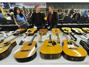 Bidders inspect some of the 300 guitars at Able Auctions in Surrey on Sunday. The collection of three hundred instruments is being sold by Dr. Barry Rich, a retired physician suffering from bipolar disorder who bought the guitars over a two year period while in a manic phase.