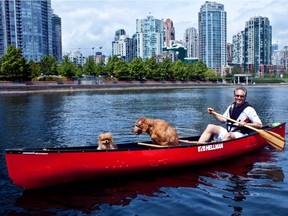 FILE PHOTO Downtown developer James Schouw paddles his canoe with canine companions Chutney, Hershey and Paprika.