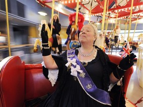 Queen Victoria (aka Heather McPherson) rides on the C. W. Parker Carousel at Burnaby Village Museum.