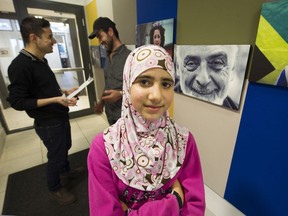Alaa Rahmoun and her father Osama (behind) get some help from Immigrant Services Society counsellor Mohammed Alsleh (left) at the society's offices in East Vancouver.