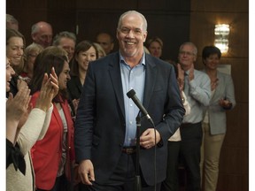 B.C. NDP Leader John Horgan is surrounded by incumbent and newly-elected NDP MLA's during a caucus meeting in Vancouver on Thursday.