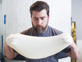 Chef David Tozer stretches dough as he makes a Neapolitan pizza at Nicli Antica in Vancouver on May 18.
