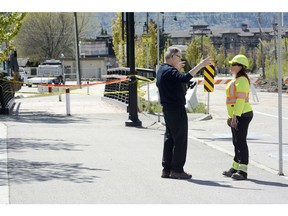 New data from WorkSafeBC shows 15 roadside workers have been killed and 229 injured when they were hit by vehicles while on the job over the past decade. Mike Trenn, left of Glenrosa talsk with Bobbi of All Safe Traffic Control where Gellatly Road was closed due to flooding.