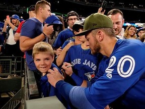 Toronto Blue Jays&#039; Josh Donaldson autographs the jersey of 7-year-old Ethan Wilson, of Calgary, Alberta, before the Blue Jays&#039; baseball game against the Seattle Mariners, Friday, June 9, 2017, in Seattle. (AP Photo/John Froschauer)