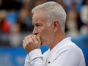 FILE - In a Saturday June 18, 2016 file photo, John McEnroe, Coach to Canada&#039;s Milos Raconic, looks across the court as Raconic plays Australia&#039;s Bernard Tomic during their semifinal tennis match on the sixth day of the Queen&#039;s Championships London. McEnroe wants to see players get fed up that they can&#039;t break through against Roger Federer and Rafael Nadal, that they remain stuck behind Novak Djokovic and Andy Murray heading into Wimbledon.(AP Photo/Tim Ireland, File)