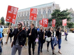FILE - In this April 1, 2015, file photo, students and other supporters protest on the University of Washington campus in Seattle, in support of raising the minimum wage for campus workers to $15 an hour. Seattle&#039;s $15-an-hour minimum wage law has cost the city jobs, according to a study released Monday, June 26, 2017, that contradicted another new study published last week. (AP Photo/Ted S. Warren, File)