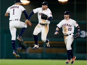 Houston Astros Carlos Correa, George Springer and Josh Reddick (left to right) ‘jump to it’ in celebration after Thursday’s 6-1 win over the visiting Oakland A’s — the Astros’ 54th victory of the season, giving them the best record in the majors.