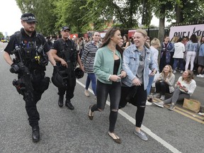 Armed police are present as crowds arrive to attend the One Love Manchester benefit concert on Sunday June 4, 2017, for the victims of last month's Manchester Arena terror attack at the Emirates Old Trafford, Manchester, England. The attack at Ariana Grande's concert last week killed more than 20 people and injured dozens of others, many of them teenagers.