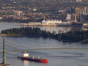 An oil tanker is guided by tug boats as it goes under the Lions Gate Bridge in Burrard Inlet, something that would increase almost seven-fold to about 400 visits a year if Kinder Morgan’s Trans Mountain pipeline expansion to its Burnaby terminus is realized.