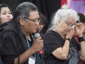 A woman wipes a tear away as she listens to Terry Ladue speak of the effects of his mother Jane Dick Ladue's murder at the National Inquiry into Missing and Murdered Indigenous Women and Girls taking place in Whitehorse on Thursday, June 1, 2017.
