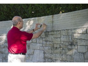 Pesi Balsara takes a picture of the name of his brother-in-law, Sam Homi Madon, on the Air India Memorial Wall in Stanley Park as he attends the anniversary of the Air India bombing on Friday, June 23 in Vancouver.