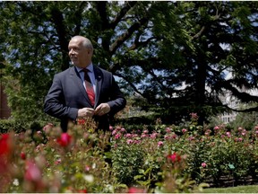 John Horgan buttons up his jacket after speaking to the media on Monday from the Rose Garden in Victoria.