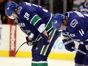 Victor Oreskovich, left, and Alex Burrows of the Vancouver Canucks hang their heads after the Boston Bruins beat the Canucks in Game 7 of the 2011 Stanley Cup Final at Rogers Arena. Burrows has played in 27 playoff games since then — 15 of them with Ottawa — but Oreskovich has played none. In fact, he only played one more NHL game.