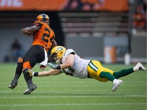 B.C. Lions' Jeremiah Johnson, left, escapes a diving tackle by Edmonton Eskimos' Odell Willis during the first half of a CFL football game in Vancouver, B.C., on Saturday, June 24, 2017.