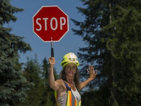 Longtime flagger Dianne Herbac demonstrates some flagging techniques at a job site in Langley in June 2017.