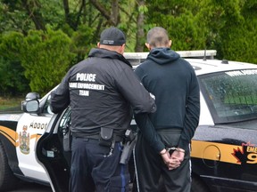 Inderdeep Minhas, 18, is pictured being arrested by an Abbotsford Police officer. Minhas was arrested by the gang task force for failing to appear in court on charges related to firearms and obstructing justice. It is in relation to the ongoing Lower Mainland gang conflict.