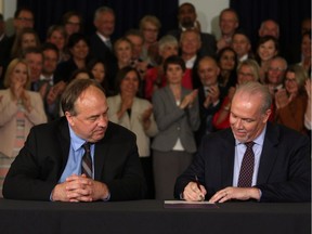 B.C. NDP leader John Horgan and B.C. Green party leader Andrew Weaver sign an agreement on creating a stable minority government during a press conference in the Hall of Honour at Legislature in Victoria, B.C., on Tuesday, May 30, 2017.