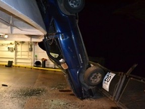 A Chevy Blazer sits vertically on the upper car deck of the docked Queen of Surrey ferry at Langale Terminal on the Sunshine Coast early Saturday. Chase Campbell, 25, has been charged in connection with the incident in which an SUV smashed through terminal security gates and was launched off a raised ramp and onto the ferry.