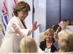 B.C. Premier Christy Clark receives high-fives before addressing a gathering in Vancouver on June 21, a day before the Liberals delivered their throne speech.