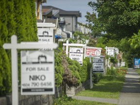 Real estate signs along Broadway near Renfrew streets in Vancouver on June 12.