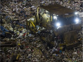 A front end loader moves garbage inside the pit at the Kent Avenue Transfer Station in Vancouver. More than two million plastic bags, 2.6 million paper coffee cups, and countless foam takeout food containers are thrown out each week in the city.